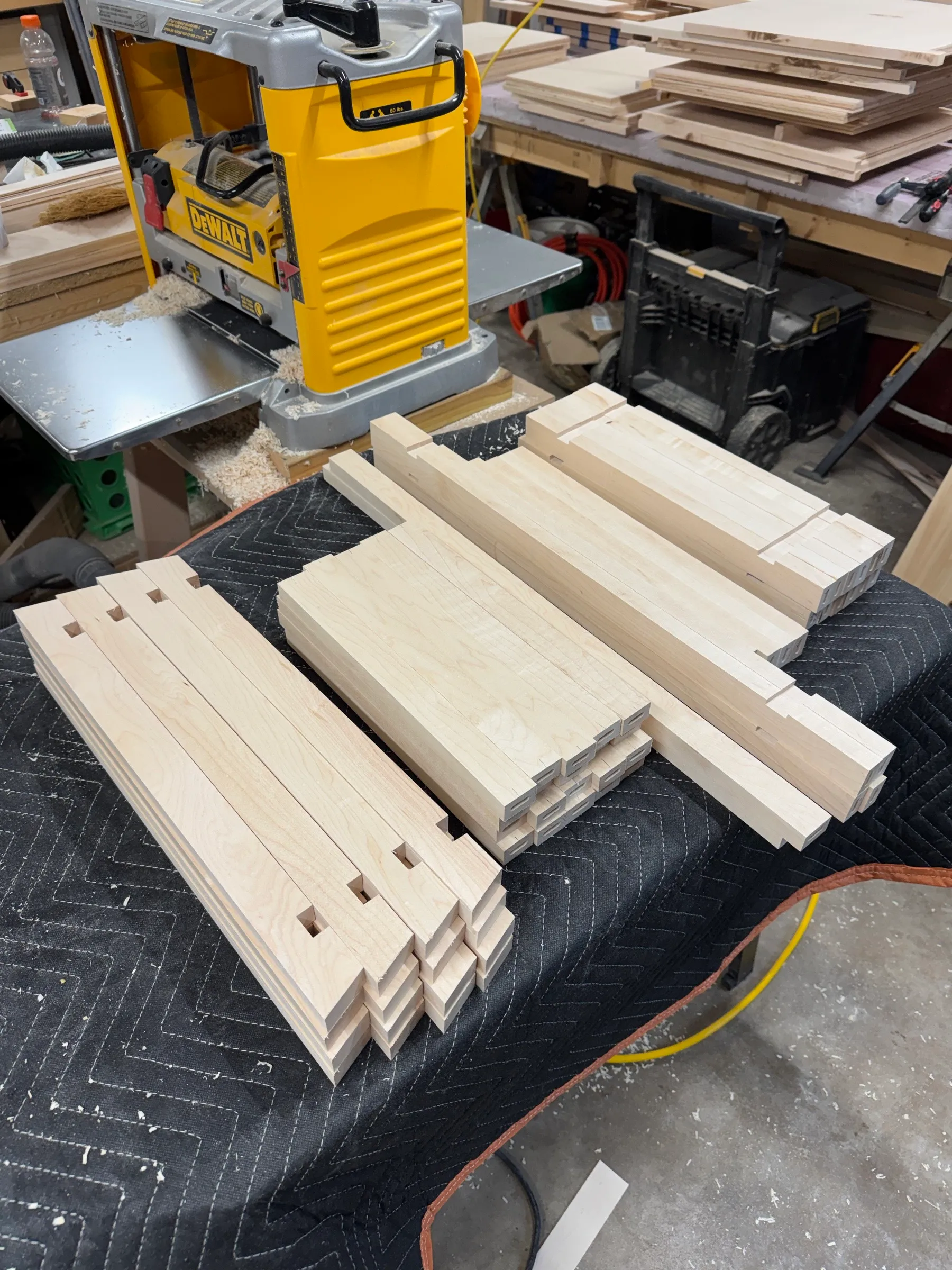 Milled solid maple frame parts laid out beside the planer, mortises cut in the posts and tenons on the rails.