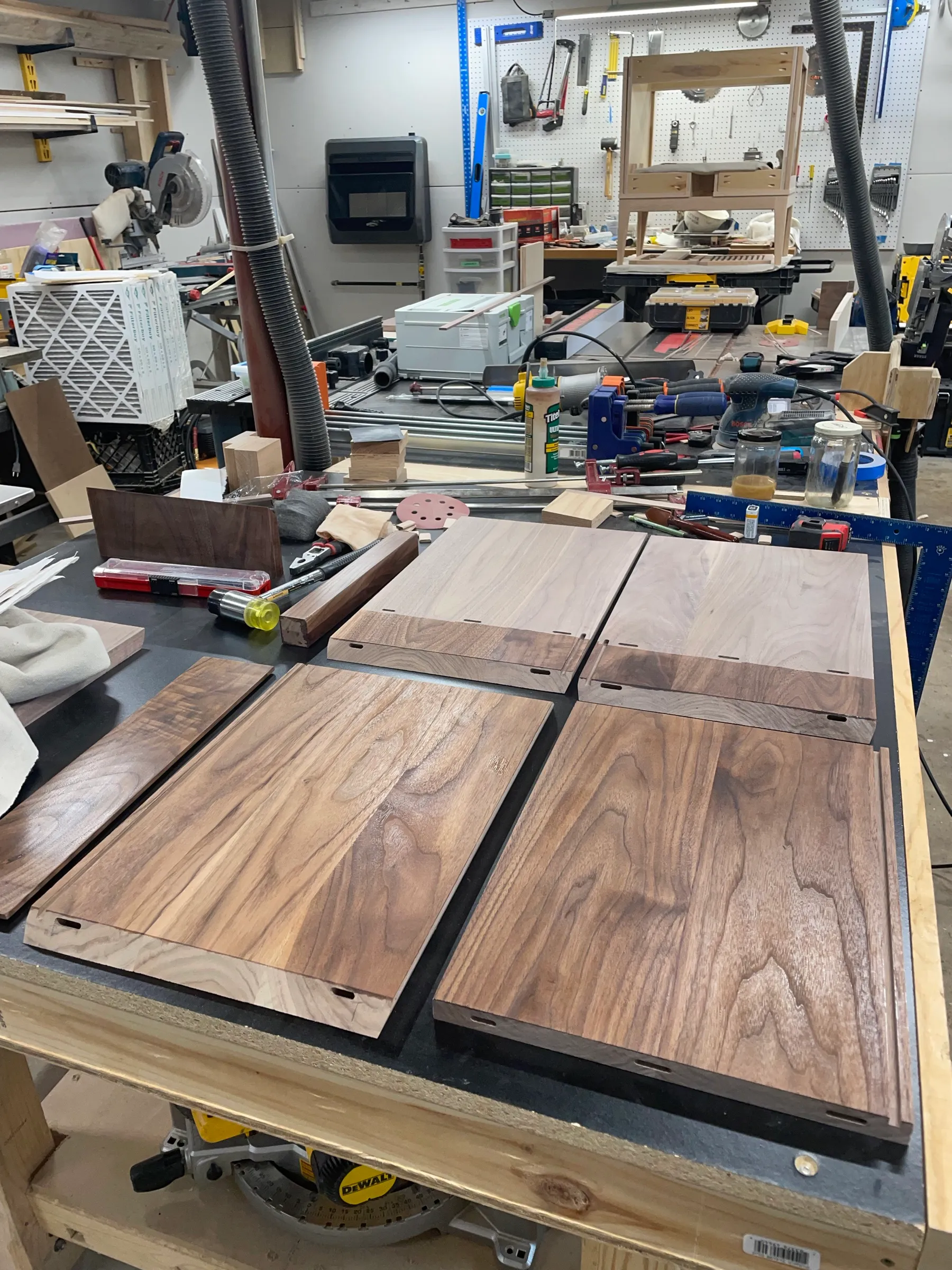 Walnut panels milled to size and laid out on the saw station, grain matched for the table.