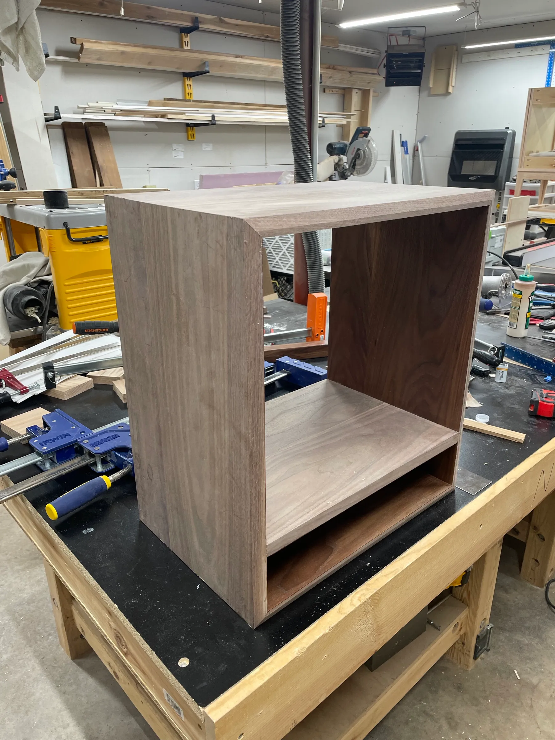 The walnut carcass glued up on the bench, the open cubby and drawer opening taking shape.