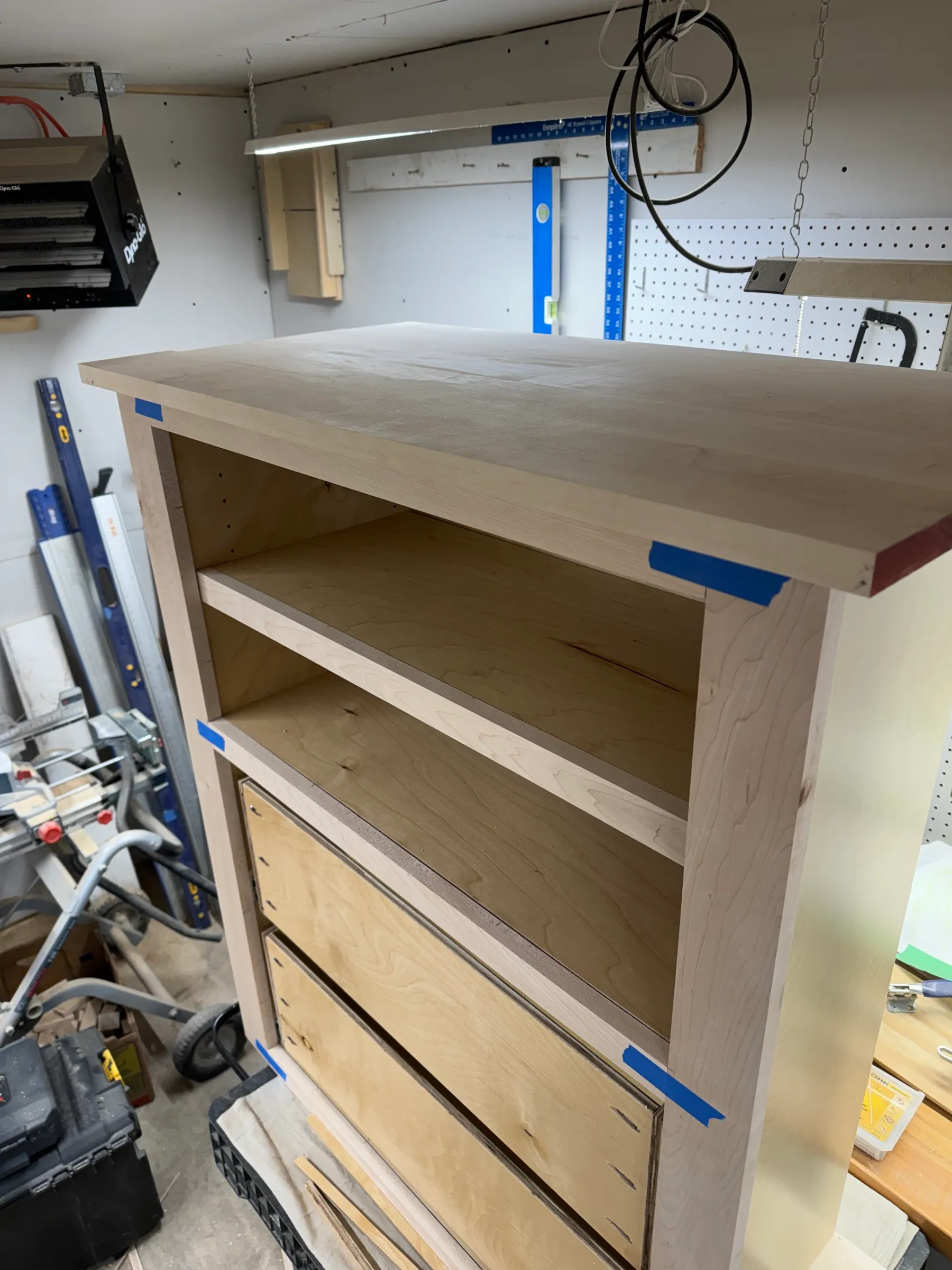 The counter cabinet on the bench with its solid maple top dry-fitted and held with blue tape.