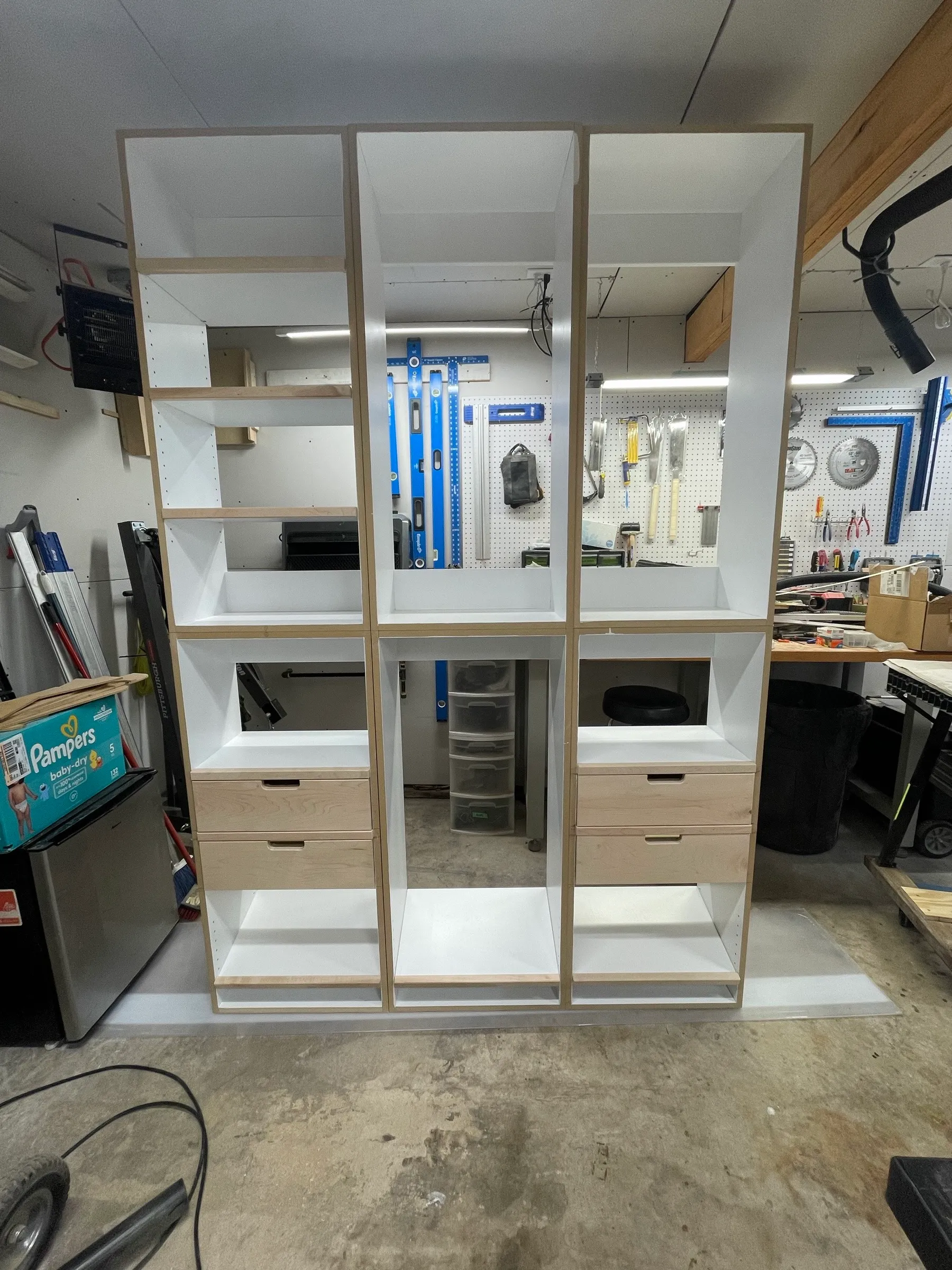 The three finished modules stood side by side in the shop for a dry fit, drawers in and shelves set.